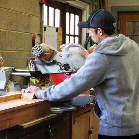 A student is using tools to build something in the Landscape Design Build course.