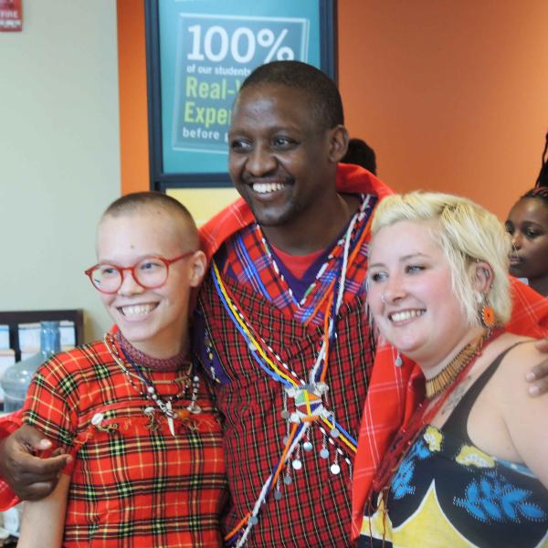 3 student in colorful outfits take a group photo