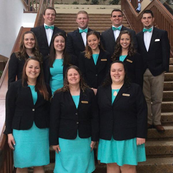 Students standing wearing matching outfits on the steps