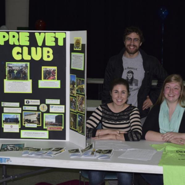 a group of students behind a table with pre-vet club materials