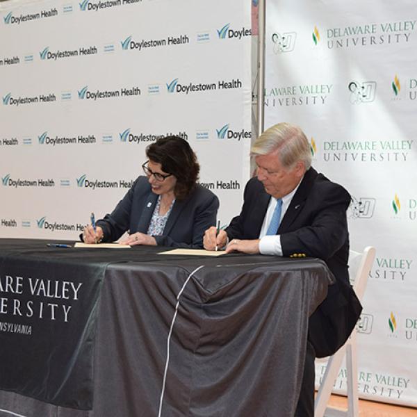 Officials sign an agreement between DelVal and Doylestown Health