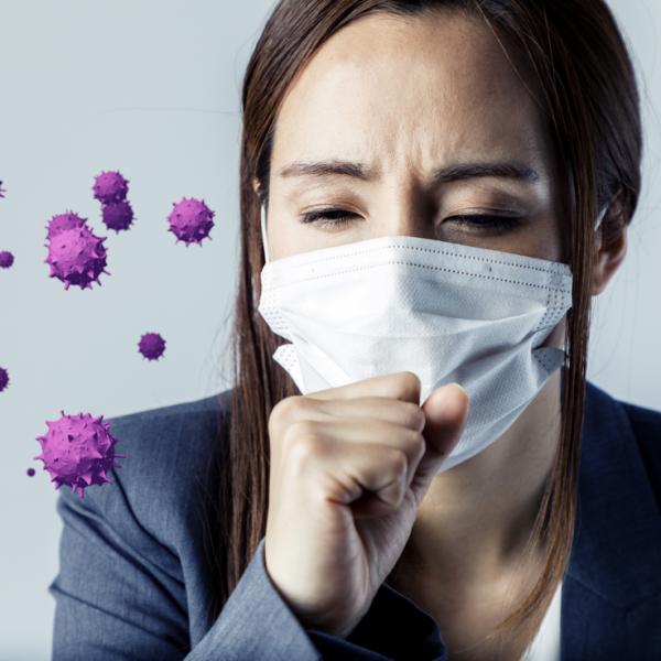 A woman wearing a mask and coughing, purple virus is in the air.