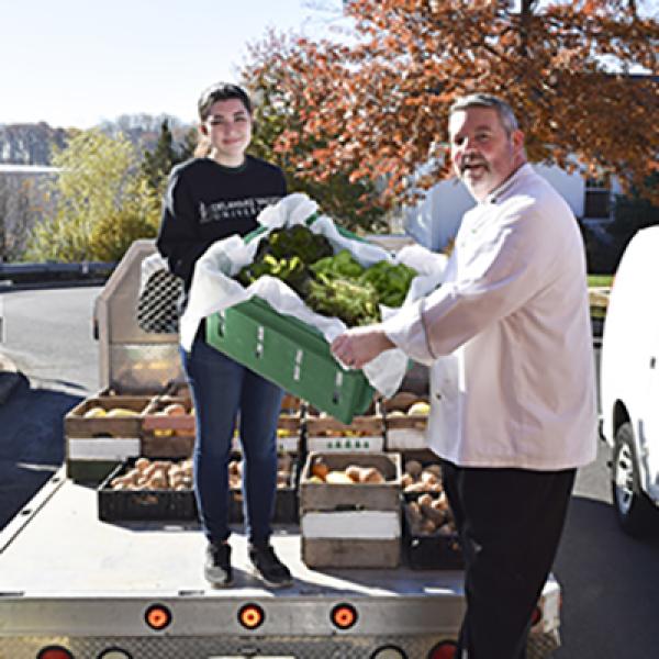Student and teacher delivering lettuce and vegetables
