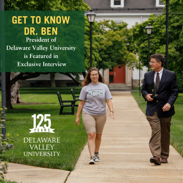 Dr.Ben is walking with a student on campus 