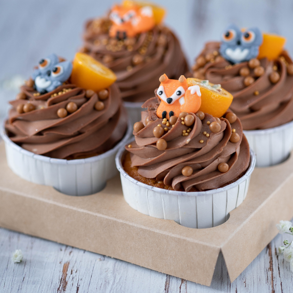 Cupcakes are designed with decorative sprinkles on a tray.