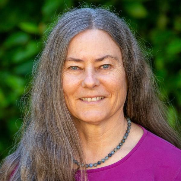Anne Bilke headshot, the backdrop is green outdoor. 