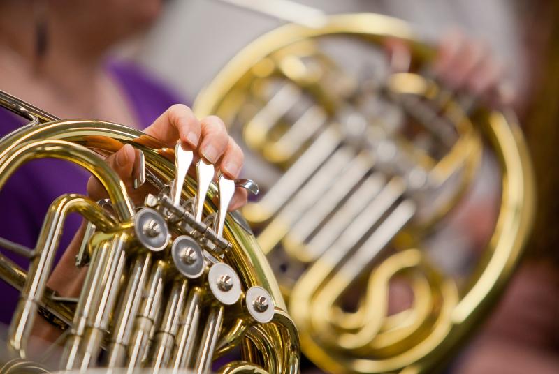 A close-up of a french horn instrument being played. 