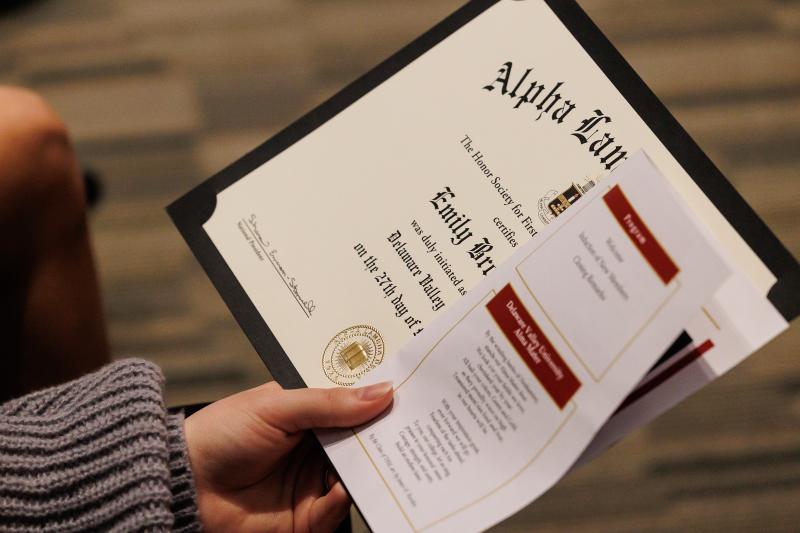 A close-up of a student holding a certificate. 