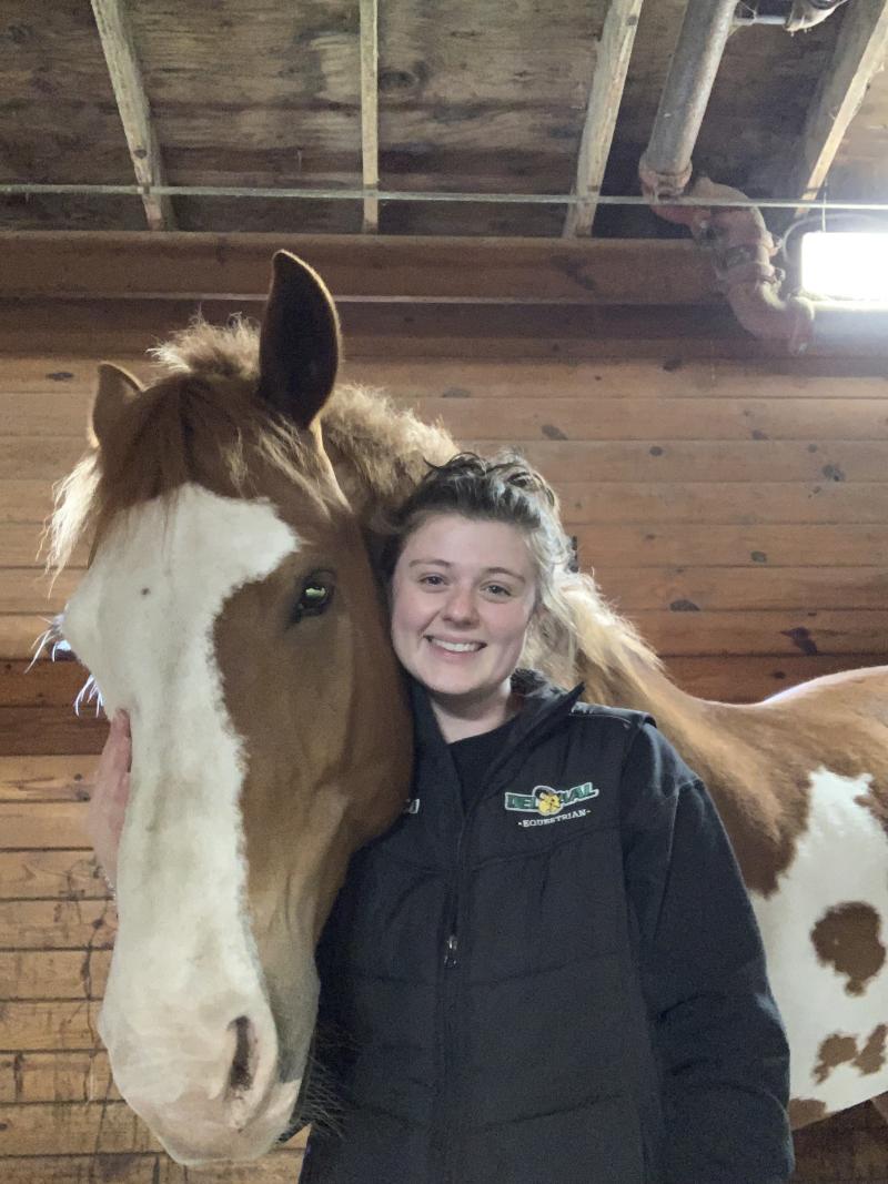 Madeleine Buzzeo poses with a horse. 