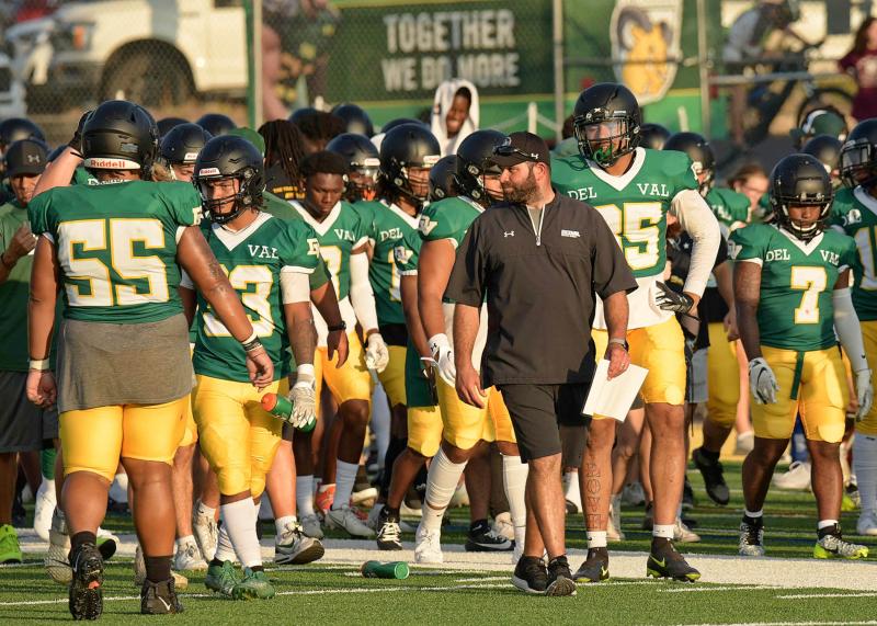 Isgro on the field with football players.