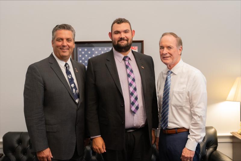 Greg Gipe at the Capital posing for a photo with two officials. 