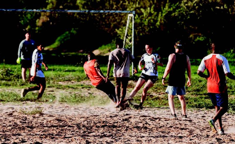 TJ is playing sports in the field of sandy land. 