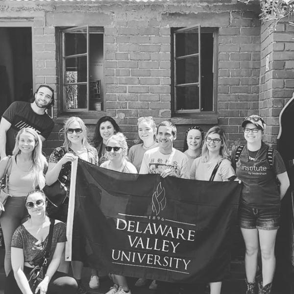 A black and white photo of classmates holding the DVU flag