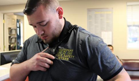 A public safety intern at Delaware Valley University uses a radio. 