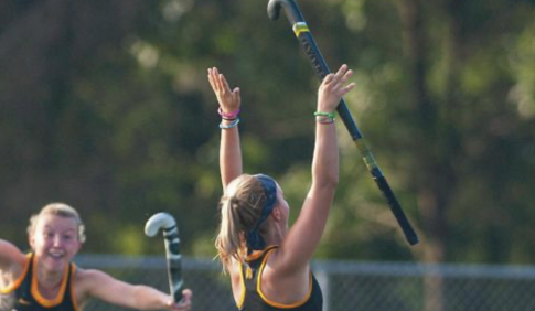 Two field hockey played celebrating a goal