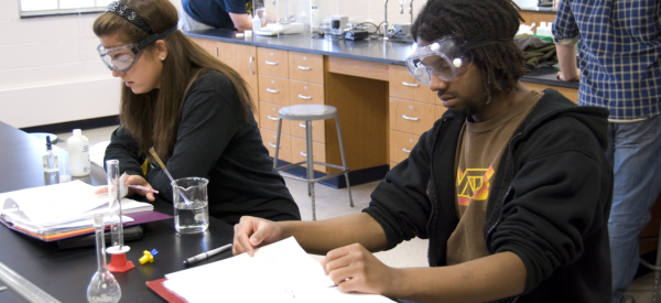 Students wearing safety goggles in a biology laboratory.