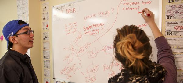 Two students interacting with word webs on a white board