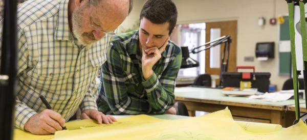 Professors showing student something with a marker