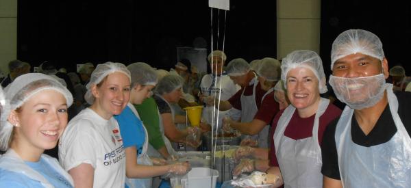 A group of volunteers packs food to fight hunger. 