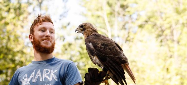 A male student holding a hawk names Waldorf.