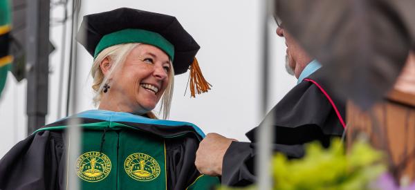 A graduate receiving her doctorate degree at commencement. 