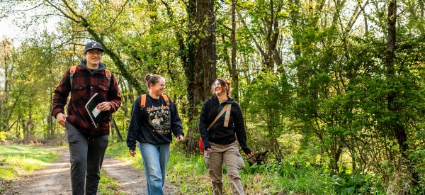 Three students in a small animal science course outdoors.