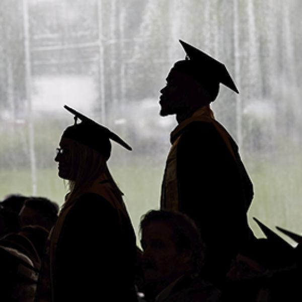 Two students in silhouette at graduation.