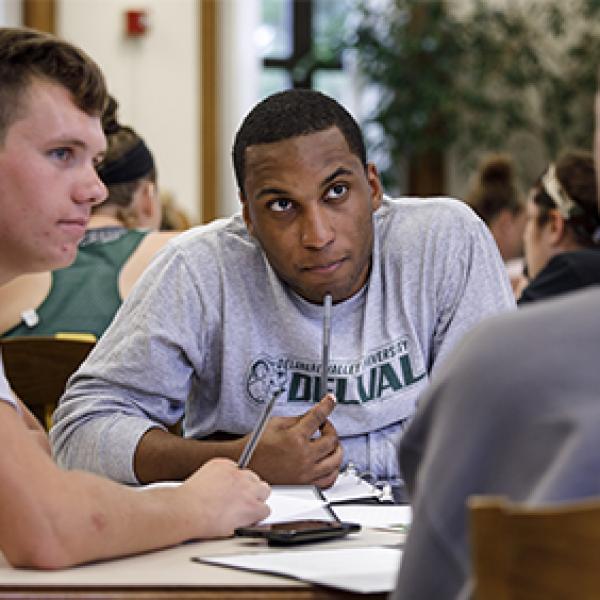 Three students work together in a library