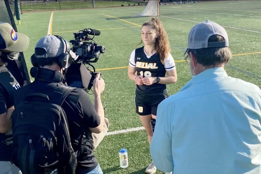 Be a storyteller video card - a soccer athlete being interview with camera operators.