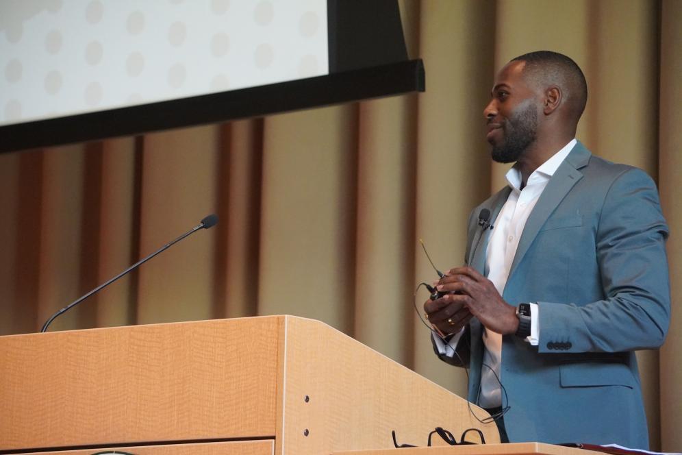 Bernard is speaking behind a podium on the life sciences building stage. 